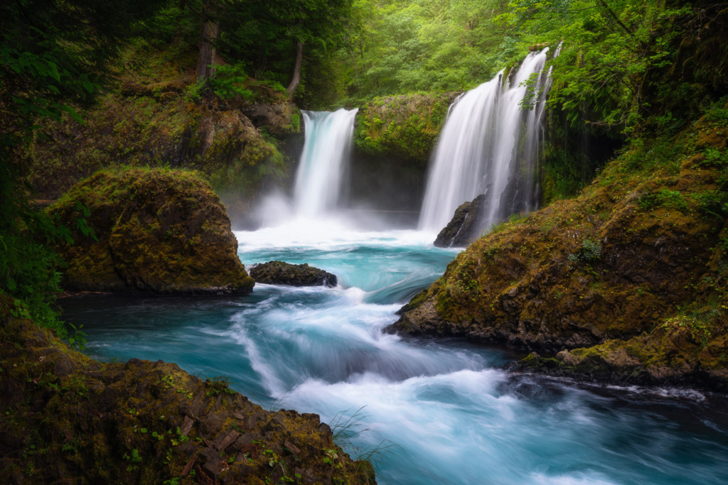 A vibrant, emerald blue waterfall during Spring in Washington